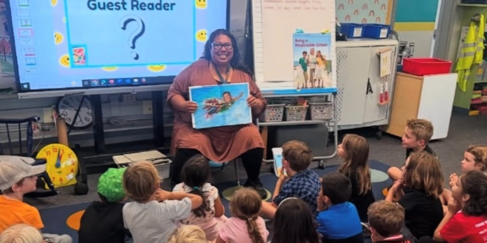 Guest reader sharing a book with Bay Park Elementary students